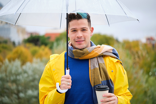 Businessman in the rain under his umbrella.