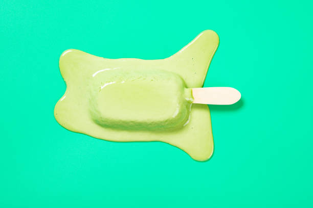 top view matcha and milk flavor popsicle in a melting process on green background