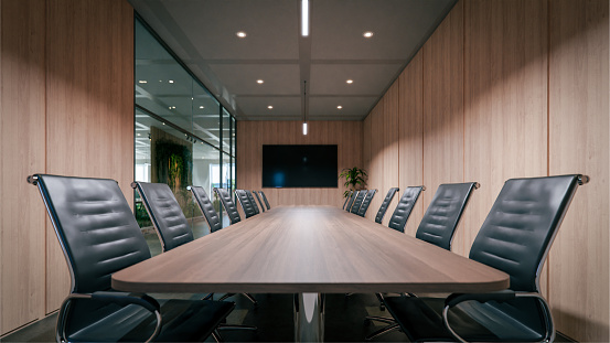 Multi-ethnic group of male and female executives sitting at conference table in modern office and exchanging ideas.