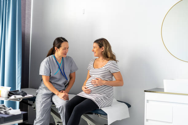new mum to be attends midwife appointment during the third trimester - human pregnancy midwife healthcare and medicine visit imagens e fotografias de stock