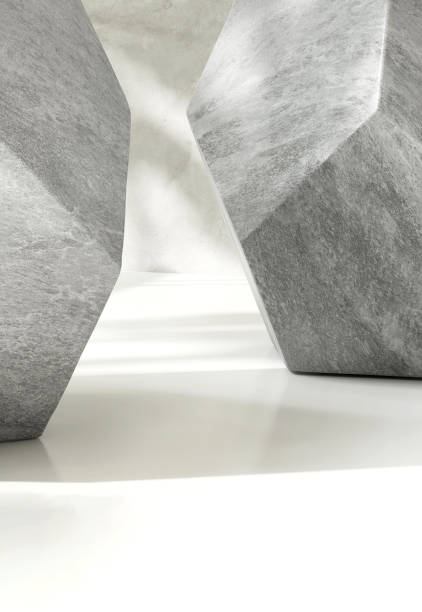 istock Two modern design gray granite geometric shape, pentagon side, in sunlight on white table countertop and polished cement wall 1498290899