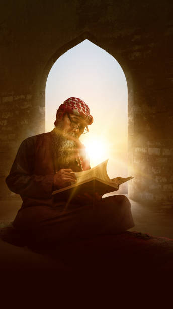 Muslim man with a beard wearing keffiyeh with agal sitting and reading the Quran on the prayer rug Muslim man with a beard wearing keffiyeh with agal sitting and reading the Quran on the prayer rug inside the mosque middle eastern ethnicity mature adult book reading stock pictures, royalty-free photos & images