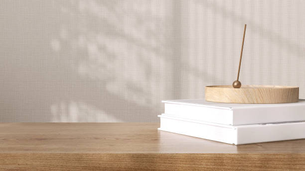 istock Blank brown wooden counter table, book in soft sunlight, leaf shadow on beige texture wallpaper wall 1498296658