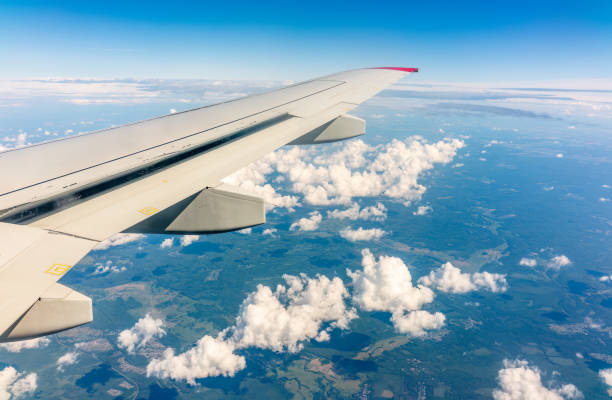 istock View from the airplane window at a beautiful cloudy sky and the airplane wing 1498298094