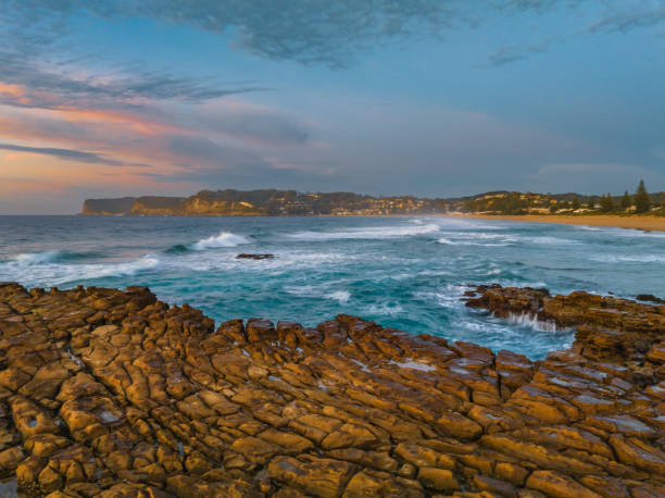 istock Ocean sunrise with rock platform and clouds 1498299234
