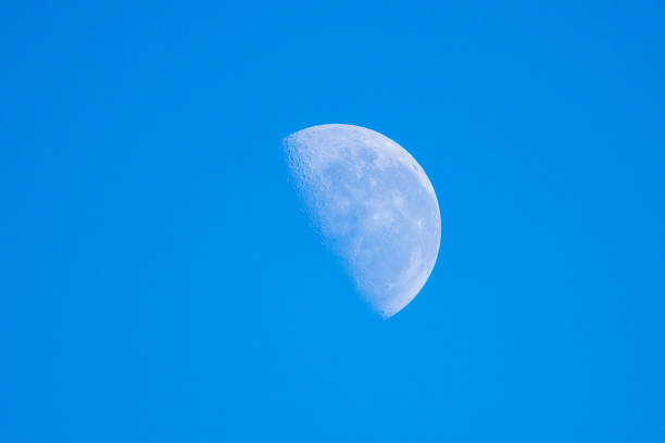 Partial moon in the blue daytime sky over Mallacoota, Victoria, Australia