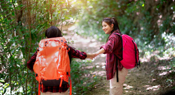 Two hikers with backpacks walking in the forest