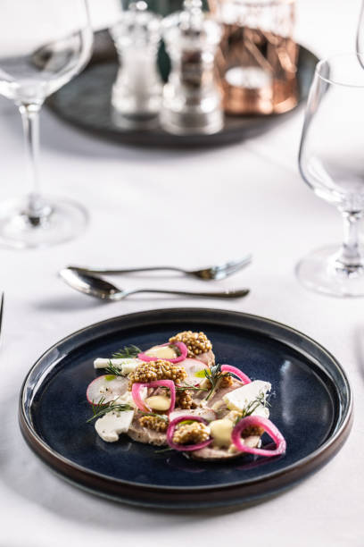 istock Restaurant appetizer with duck or goose liver pate with vegetable presented on a dark plate and white table. 1498313164