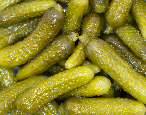 Marinated cornichons texture food background. Macro shot. Tasty whole green cornichons pattern