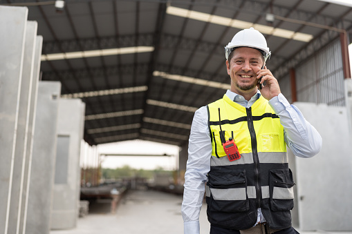 Portrait caucasian engineer man working with smart phone at precast site work