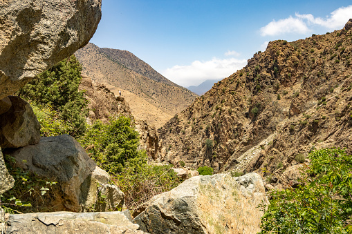 A lone man standing on a rock at Ourika Valley near Setti Fatma in Atlas Mountains, Morocco