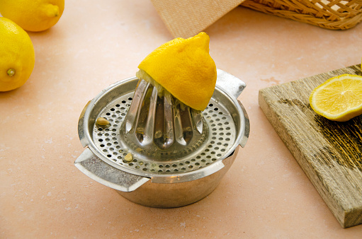 Close up of half a lemon on a hand juicer. Marbled background
