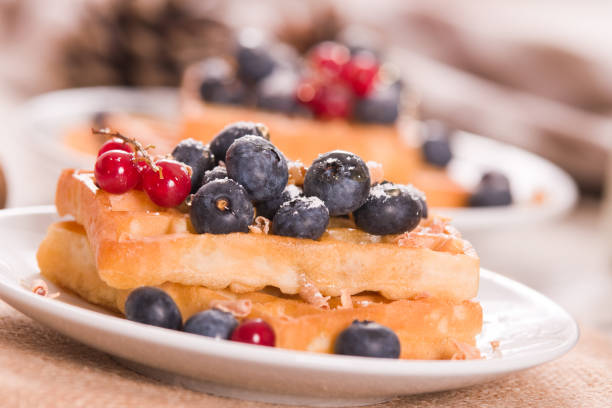 istock Waffles with red currant and blueberries on white dish. 1498321083