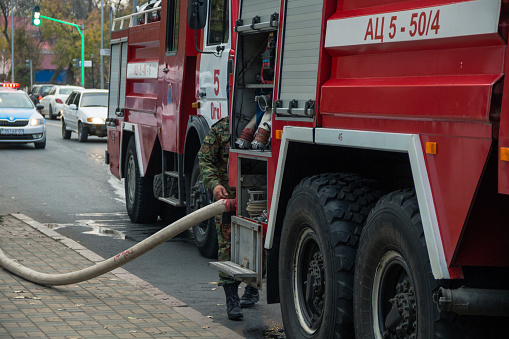 Uralsk, Kazakhstan (Qazaqstan), 24.10.2019 - A firefighter connects a hose to a fire engine. Fire trucks arrived at the site to put out the fire.