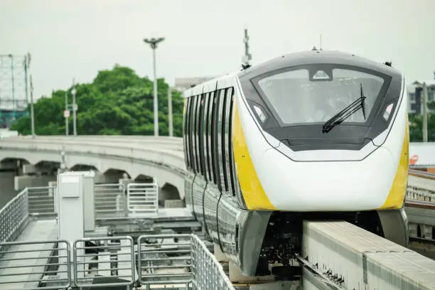 Elevated monorail train on rail. Public transit monorail. Modern mass transit. Electric vehicles. Rail transportation. Urban transport. Commuter train. Monorail technology. Rapid transit in the city.