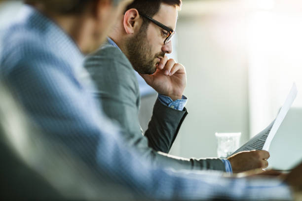 istock Pensive businessman reading documents in the office. 1498322781