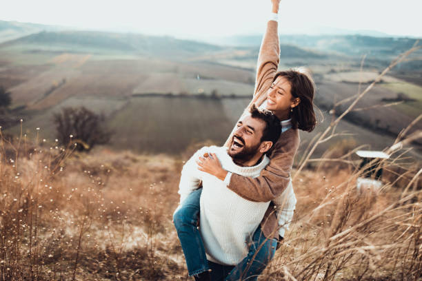 istock Young cheerful couple having fun while piggybacking on a hill. 1498324468