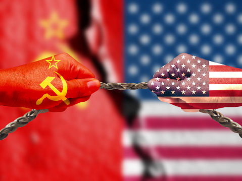 The tug of war and repeated exposure of the Soviet and American flags. The tug of war is a metaphor for the cold war between two countries. Flag of the USSR (1922-1991). American flag (50 stars)