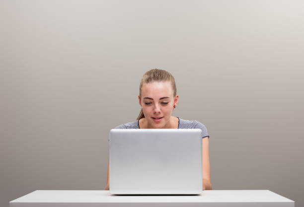 ¿chica con portátil, sonrisa o molestia? - desk job fotografías e imágenes de stock