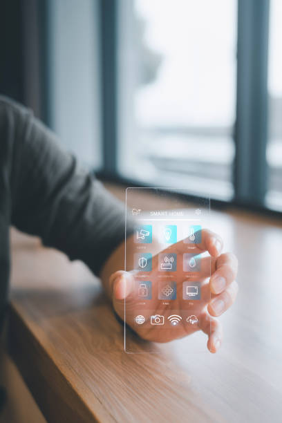 istock Young man uses transparent, futuristic smartphone to activate light using smart home software. 1498328774
