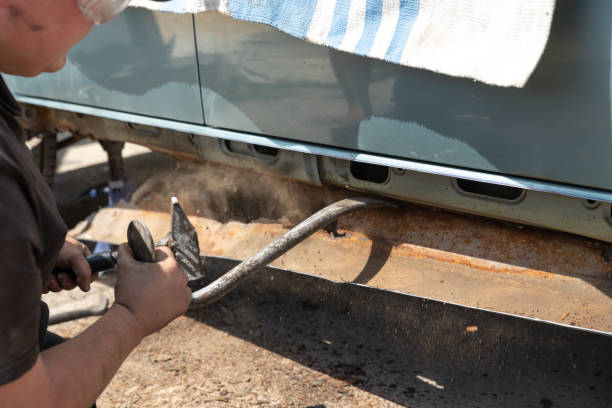 istock Auto mechanic removes the rusty threshold in an old car. 1498332776