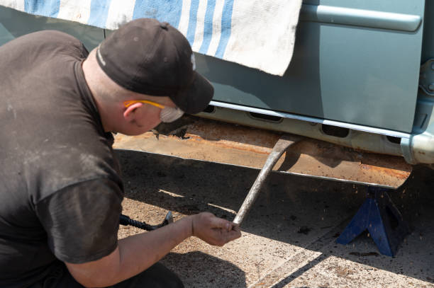 istock Auto mechanic removes the rusty threshold in an old car. 1498333028