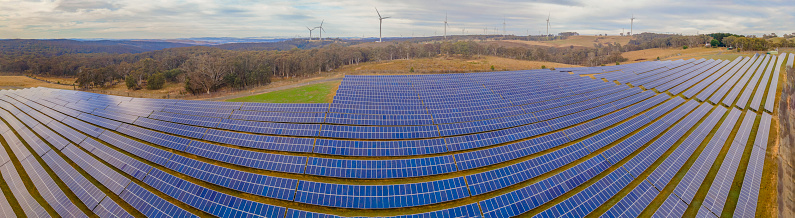 Panoramic low aerial view of the hybrid Gullen Solar Farm and Gullen Range Wind Farm for renewable clean energy supply located at Bannister in the Upper Lachlan Shire, NSW, Australia