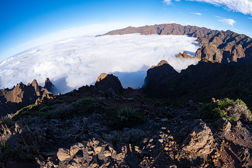 Aerial sunrise view above the clouds looking at the stunning volcanic rock formations of the Caldera de Taburiente National Park and Roque de los Muchachos