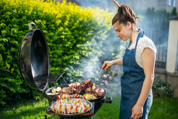 istock Woman barbecuing with open flame grill outdoor. 1498342453