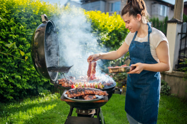 istock Woman barbecuing with open flame grill outdoor. 1498342461