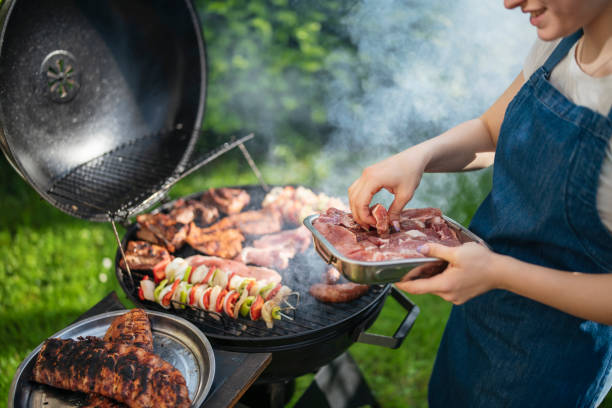 istock Woman grilling meat and vegetables on the barbeque. 1498342476