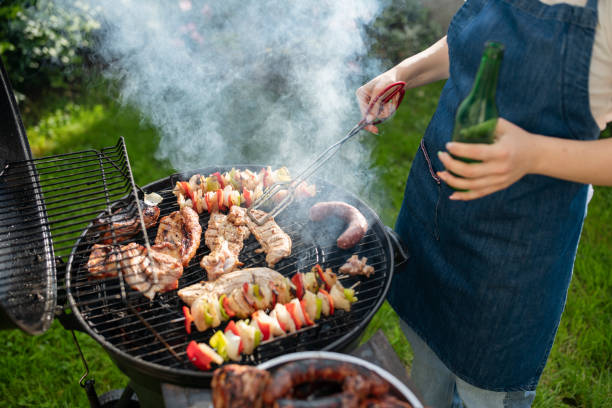 istock Woman barbecuing with open flame grill outdoor. 1498342480