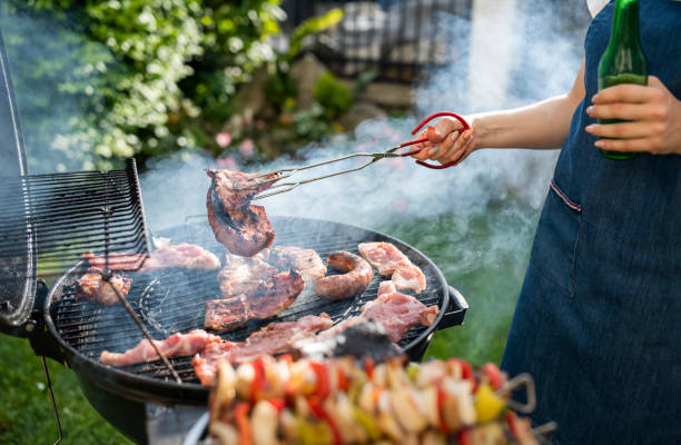 istock Woman making dinner on the grill barbeque. 1498342489
