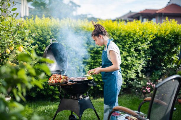 istock Young woman cooking dinner on barbecue grill at back yard. 1498342511