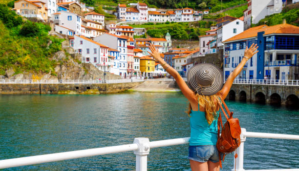 Traveler woman tourist enjoying beautiful fishing village in Asturias, Cudillero in Spain stock photo