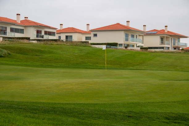 campo de golfe verde perfeitamente cortado, em um complexo habitacional à beira-mar - golf ball spring cloud sun - fotografias e filmes do acervo