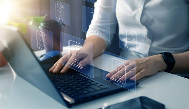 istock Businesswoman working on laptop with virtual screen. Process automation to efficiently manage files. Online documentation database and document management system concept. 1498350533