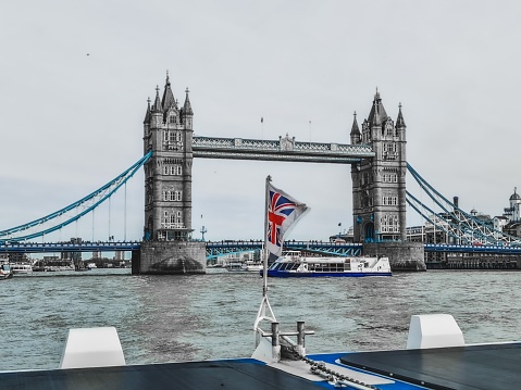 London, United Kingdom – February 06, 2021: A majestic sailing boat gliding across the River Thames, with the iconic Tower Bridge in the background