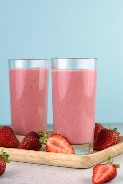 istock Strawberry smoothie or milkshake with berries on a blue background. Summer beverages. Copy space. 1498359540