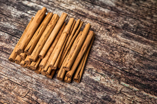 Closeup of Sri lankan cinnamon sticks on wooden table, top view. Rustic style natural spices of ceylon cinnamon sticks for advertising banner or poster. Delicious healthy concept. Copy ad text space primer plano de palitos de canela de sri lanka sobre mesa de madera, vista superior. especias naturales de estilo rústico de palitos de canela de ceilán para banner publicitario o cartel. delicioso concepto saludable. copiar el espacio de texto del anunc