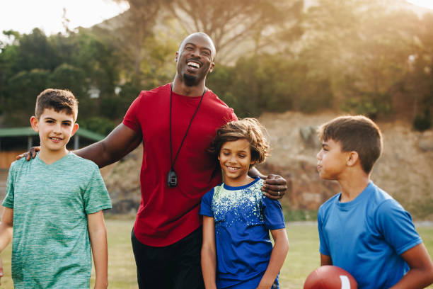 istock Primary school coach standing with his football team 1498360860
