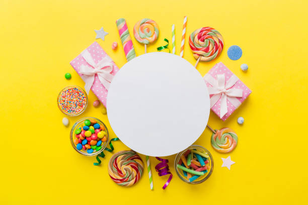 istock Flat lay holiday composition. Paper blank, lollipop, birthday decorations on Colored background. Top view, copy space for text 1498361183