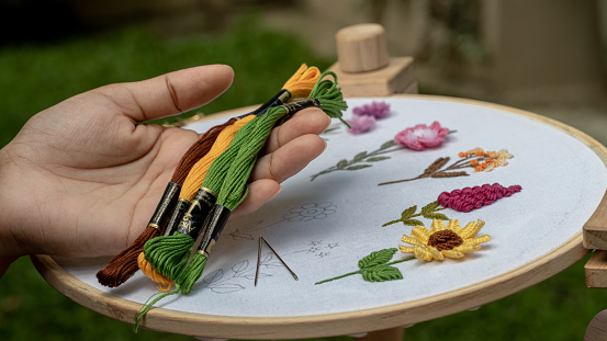 Handcrafted Beauty: Embroidery Floss Threads and Sewn Flowers on a Stand Hoop