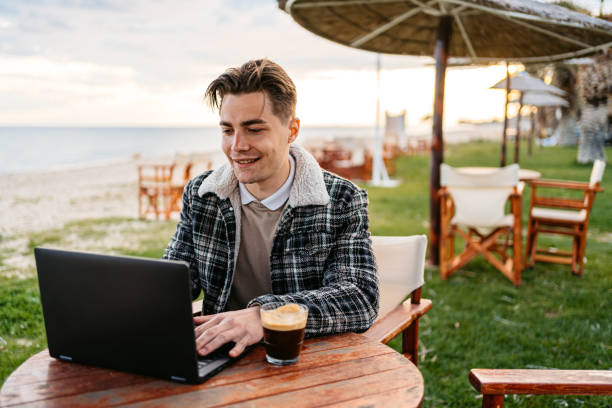 istock Young Man Working On Laptop In A Beach Bar In Greece 1498364744