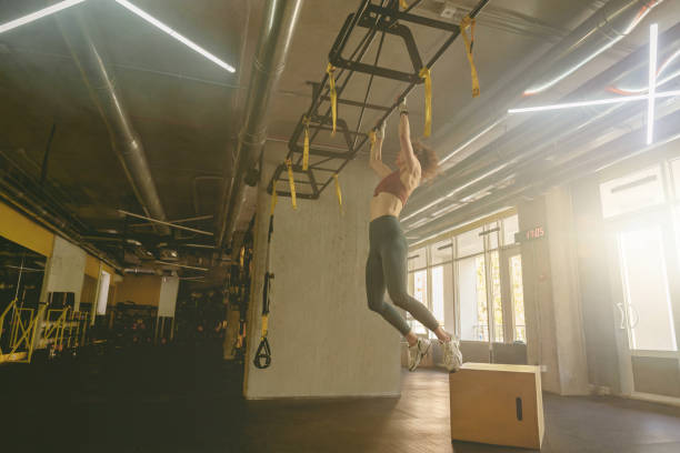 istock Strong young woman pulls herself up and does a workout in the gym. Motivation and strength 1498366918