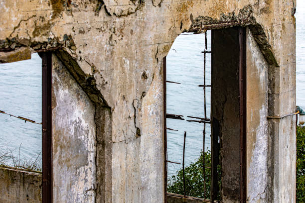 ruines de la fenêtre d’échange de la prison fédérale de l’île d’alcatraz aux états-unis dans la baie de la ville de san francisco, californie, états-unis. surveillance sous un ciel nuageux. - alcatraz island prison penitentiary officer photos et images de collection