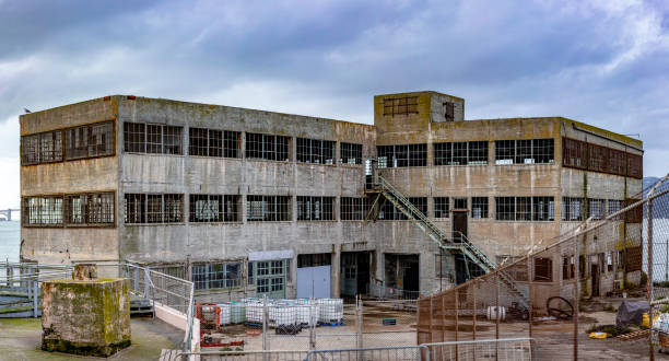 modell eines industriegebäudes des bundesgefängnisses der insel alcatraz in den vereinigten staaten von amerika in der bucht von san francisco, kalifornien, usa. überwachung unter bewölktem himmel. - alcatraz island prison penitentiary officer stock-fotos und bilder