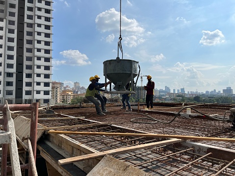 Kuala Lumpur, Malaysia – June 10, 2023: A construction worker team is hard at work on a steel structure in Kuala Lumpur, Malaysia.