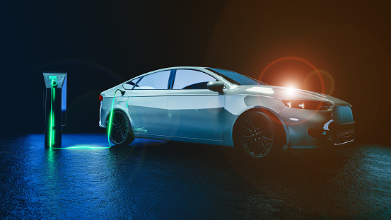 The electric car is charging, isolated on a black background - a futuristic image with light effects symbolizing the flow of electricity from the charger to the car's battery.