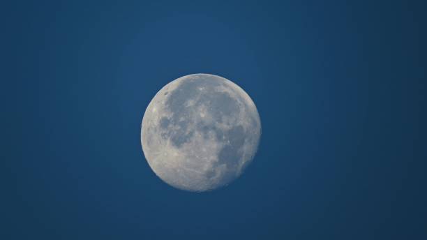 istock Full moon isolated in the blue sky. 1498378403